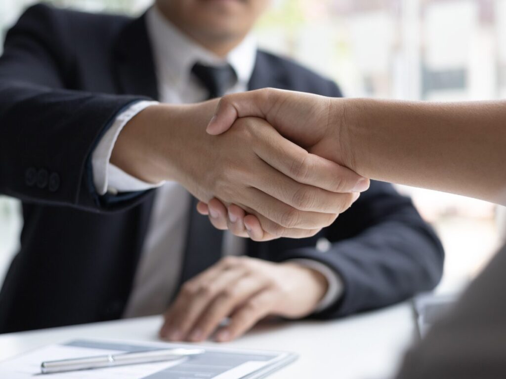 会社員同士が握手している様子